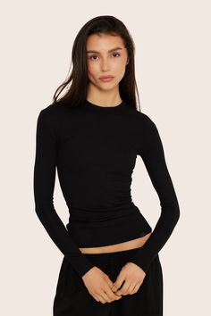 Express your unique style with our Essential Long Sleeve in Onyx. This updated version of the SET Long Sleeve boasts the same fit with a fold-over tab highlighting SET branding. Crafted from our ribbed modal fabric, it's an essential piece for your fashion-forward look. Fitted Long Sleeve Loungewear Top, Sleek Fitted Tops For Layering, Sporty Tops With Minimal Stretch For Layering, Seamless Long Sleeve Top For Layering, Sleek Fitted Long Sleeve Top, Fitted Long Sleeve Sporty Top, Fitted Solid Top For Loungewear, Stretch Long Sleeve Tops With Seamless Collar, Sleek Tops For Layering