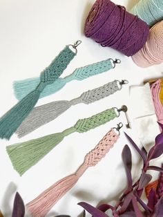 yarn and crochet tassels laid out on a table next to flowers