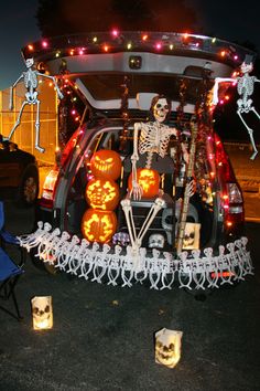 a car decorated for halloween with skeletons and pumpkins