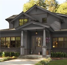 the front view of a gray house with lots of windows