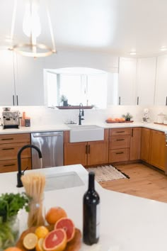 a kitchen filled with lots of white counter tops and wooden cabinets next to a sink