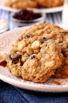 two cookies on a plate with raisins and white chocolate