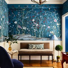 a living room with blue walls and floral wallpaper on the walls, along with a couch