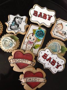 decorated cookies are arranged on a plate with the words baby, mommy, and daddy