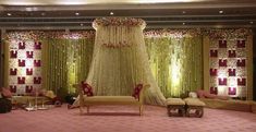 a room decorated in pink and gold with flowers on the ceiling, couches, and curtains