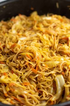 a pan filled with noodles and vegetables on top of a stove