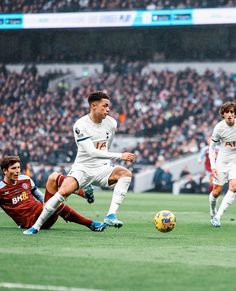 the soccer players are trying to kick the ball in front of the opposing team mates