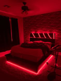 a bed with red lights on the headboard and foot board in a room that has brick walls