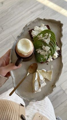 a person holding a plate with food on it and spoon in the other hand,