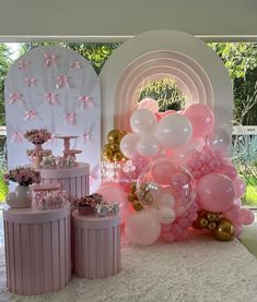 pink and gold balloons are on display at a birthday party