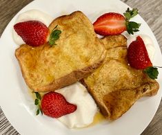 two pieces of french toast with whipped cream and strawberries