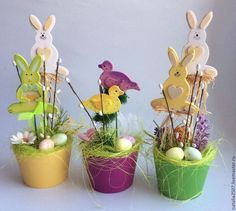 three potted plants with easter decorations in them