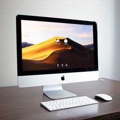 an apple desktop computer sitting on top of a wooden desk