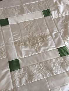 a white quilt with green trim on it