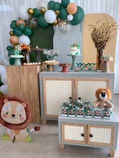 a table with balloons, decorations and stuffed animals on it in front of a dresser