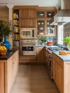 a kitchen filled with lots of wooden cabinets and counter top space next to a window