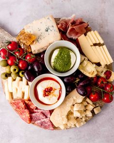 an assortment of cheeses and meats on a platter