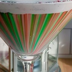 a glass filled with candy canes sitting on top of a counter