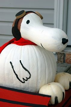 a pumpkin shaped like a dog sitting on top of a red box with its eyes closed