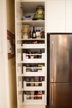 an organized pantry in a kitchen with stainless steel refrigerator and dishwasher on the side