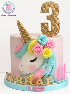 a pink and blue cake with a unicorn on top