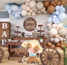 a baby shower is decorated with balloons and farm animals, such as a cow in a wheelbarrow