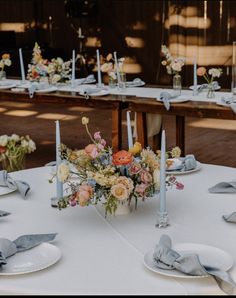 the table is set with flowers and candles