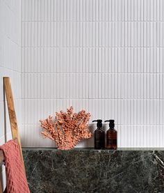 a bathroom with marble counter tops and white tiles