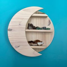 a wooden moon shelf with rocks in it