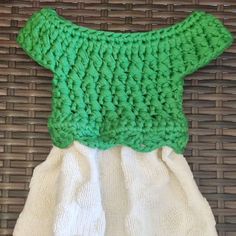 a green and white dress sitting on top of a wicker basket