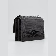 Saint Laurent medium shoulder bag in crocodile-embossed calf leather. A dramatic monochromatic bag can be worn over the shoulder or across the body. Tonal hardware black matte hardware Chain and leather shoulder strap can be doubled, 20" drop. Flap top with snap closure. Exterior, hanging covered key ring. Signature interlocking YSL logo. Slip pocket under flap. Three inside open compartments. Cotton and leather lining. Item weighs approx. 2.9 lb./ 1.3 kg. 6.3"H x 8.7"W x 3.2"D. Made in Italy. Formal Crossbody Shoulder Bag With Crocodile Pattern, Designer Crocodile Pattern Shoulder Bag For Evening, Evening Shoulder Bag With Crocodile Pattern, Black Matte Hardware, Ysl Crossbody, Ysl Crossbody Bag, Ysl Logo, Black Matte, Bergdorf Goodman