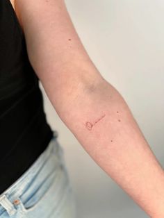 a woman's arm with a small tattoo on the left side of her arm