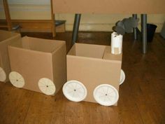 three cardboard boxes with wheels on the floor