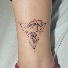 a woman's foot with a small tattoo on the side of her leg and an arrow in the middle