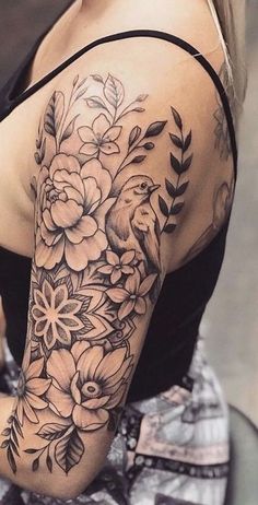 a woman's arm with flowers and birds on it