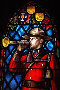 a stained glass window with a man in uniform holding a trumpet and wearing a hat