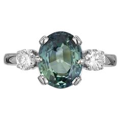 an oval cut green sapphire and three diamond ring