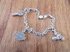 "THIS IS A VINTAGE STERLING SILVER, HARLEY DAVIDSON CHARM BRACELET. IT IS A GENUINE HARLEY ITEM. IT WOULD WORK WELL FOR A LARGER WRIST AS IT MEASURES 8 1/2\" LONG. HAS THREE NICE CHARMS THAT ARE A NICE SIZE. EACH CHARM HAS A SPRING CLASP SO IT CAN BE TAKEN OFF AND PUT ON A CHAIN etc. OR MOVED. THIS BRACELET IS CLEAN AND IS IN NICE CONDITION. IT WEIGHS 20.2gm. WORTHY OF BEING A GIFT. MARKED 925 FOR STERLING SILVER. THIS SHOP COMBINES SHIPPING. JUST PUT ALL ITEMS IN YOUR CART FIRST, THEN PAY FOR T Classic Sterling Silver Bracelet With Charms, Classic Sterling Silver Charm Bracelet Hallmarked, Classic Silver Charm Bracelet, Classic Sterling Silver Charm Bracelet For Formal Occasions, Classic Charm Bracelet Jewelry, Classic Engraved Sterling Silver Charm Bracelet, Classic Silver Jewelry With Charms, Classic Collectible Nickel-free Jewelry, Nickel-free Classic Collectible Jewelry