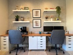 an office with two computer desks and shelves on the wall above them is shown