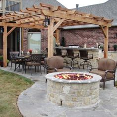 an outdoor patio with fire pit surrounded by chairs