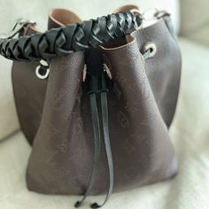 Only Used A Few Times, Excellent Condition. Comes With Original Box, Bag And All Tags! The Muria Bucket Bag Is Made From Mahina Calf, A Perforated Leather With A Discreet Monogram Motif. Supple And Sophisticated, It Is A Pleasure To Carry, Either By The Braided Top Handle Or The Long Leather Strap, Which Adjusts For Short- And Long-Shoulder Or Hands-Free Cross-Body Wear. Crafted Signature Details Include A Name Tag And Keybell In Smooth Calfskin. 9.8 X 9.8 X 7.9 Inches (Length X Height X Width) Mahina Perforated Calf Leather Calf-Leather Trim Microfiber Lining Silver-Color Hardware 2 Compartments Separated By Locked Zipped Pocket Leather Cord To Secure Belongings Name Tag Keybell 4 Prot Perforated Leather, Box Bag, Name Tag, Leather Trim, Leather Cord, Hands Free, Leather Trims, Louis Vuitton Bag, Top Handle