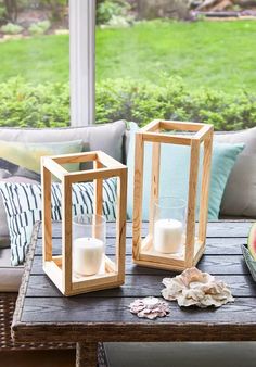 two wooden lanterns sitting on top of a table next to an apple and watermelon