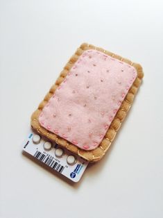 a piece of bread with pink icing on it sitting next to a stick of toothpaste