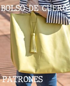 a woman holding a yellow purse with the words bolso de cuero on it