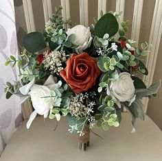 a vase filled with white and red flowers on top of a table