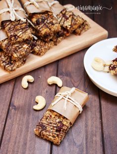 homemade granola bars with peanut butter and cashews on a wooden table next to a white plate