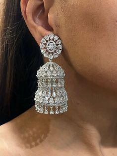 Introducing our **Exquisite American Diamond Jhumka Earrings** - a perfect blend of timeless elegance and sparkling sophistication. These stunning earrings feature meticulously crafted American diamonds that capture and reflect light, creating a dazzling effect. The traditional Jhumka design is enhanced with a modern twist, making these earrings a versatile accessory for any occasion, from festive celebrations to elegant soirées. Lightweight and comfortable, they offer enduring beauty and qualit Luxury American Diamond Bridal Earrings For Diwali, Luxury Fusion Style American Diamond Jhumkas, Silver Jhumkas For Reception, Luxury Latkans Earrings For Formal Occasions, Elegant Teardrop Jhumkas, Elegant Formal Chandelier Earrings With Latkans, Silver Fusion Jhumkas For Reception, Elegant Chandelier Earrings With Latkans For Reception, Luxury Chandbali Earrings For Party