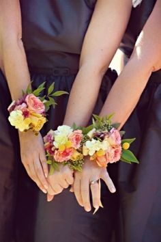 two bridesmaids holding bouquets of flowers in their hands at the same time