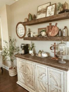 a room with some shelves on the wall and pictures above it, along with other items