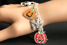 A collection of silver plated Halloween themed charms combined with five enameled Jack o'Lantern charms have been dispersed around a shimmering silver plated bracelet chain in this handmade charm bracelet. This Halloween charm bracelet is then completed with a lobster clasp and a 1/2 inch of chain at the end for adjustable sizing. Charms in this bracelet include five enameled jack o' lantern charms, haunted house charm, grim reaper charm, masquerade mask charm, and screaming skull charm. I also Pumpkin Bracelet, Screaming Skull, Halloween Charm Bracelet, Dog Charm Bracelet, Handmade Charm Bracelets, Halloween Bracelet, Halloween Charms, Silver Plated Bracelet, Family Jewellery